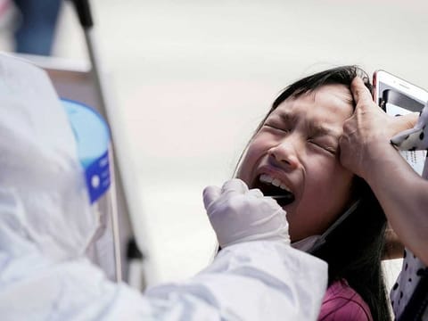 A child reacts while undergoing nucleic acid testing in Wuhan, the Chinese city hit hardest by the coronavirus disease (COVID-19) outbreak, Hubei province, China May 16, 2020.