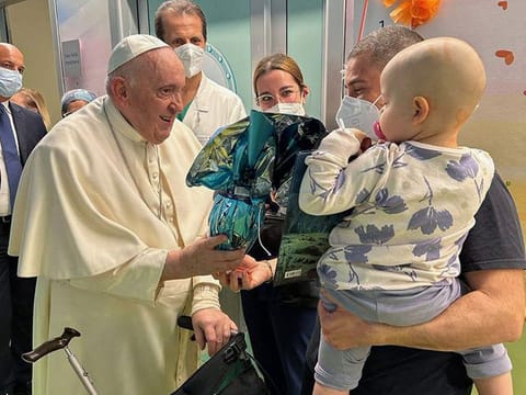 This photo taken and handout by The Vatican Media on March 31, 2023 shows Pope Francis visiting children at the oncology ward of the Gemelli hospital in Rome, the same hospital where the Pope was admitted to another ward on March 29 for bronchitis.