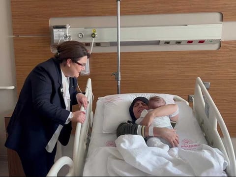 Earthquake survivor mother Yasemin Begdas reunites with her baby girl Vetin as Derya Yanik, Minister of Family and Social Services, looks on at a hospital in Adana, Turkey March 31, 2023.
