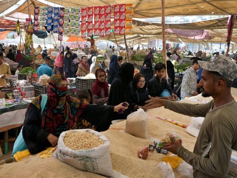 People shop at a bazaar setup by provincial government to provide items on discounted rates in Karachi in Ramadan.