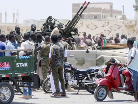 Sudanese greet army soldiers, loyal to army chief Abdel Fattah al-Burhan, in the Red Sea city of Port Sudan on April 16, 2023.