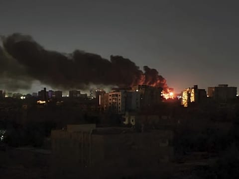 Smoke rises over the horizon as a fire burns after a strike in Khartoum.