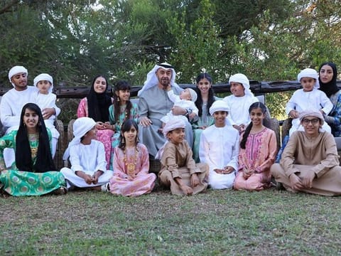 The image features the President His Highness Sheikh Mohamed bin Zayed posing alongside his loved ones, capturing the spirit of the holiday.