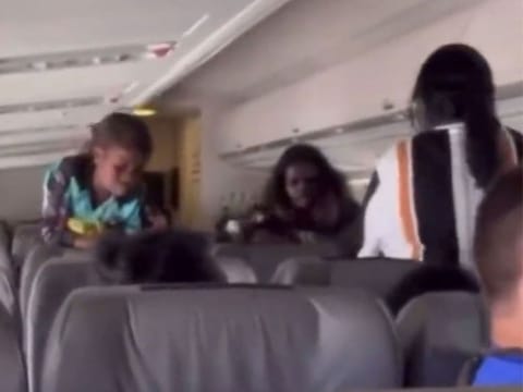Footage shows a passenger holding a glass bottle above their head, apparently to strike another passenger.