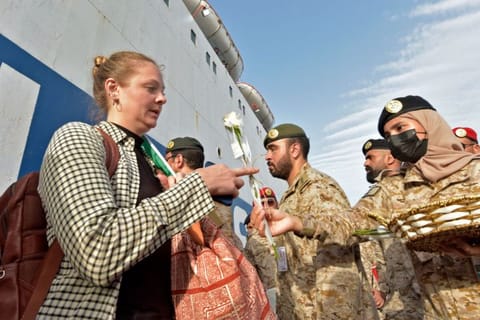 Members of the Saudi Navy Forces welcome evacuees arriving at King Faisal navy base in Jeddah on April 26, 2023 following a rescue operation from Sudan amid a US-brokered ceasefire between the country's warring generals.