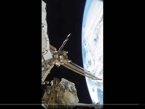 Still from clip showing Al Neyadi between Earth and the space station