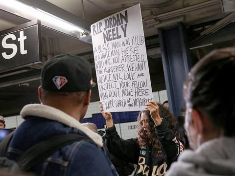 A woman holds a sign during a protest at the Broadway-Lafayette subway station, after a 30-year-old Jordan Neely acting erratically on a F subway train died on Monday afternoon after a fellow rider restrained him with a chokehold according to the police and a video of the encounter, in New York City, on, May 3, 2023.