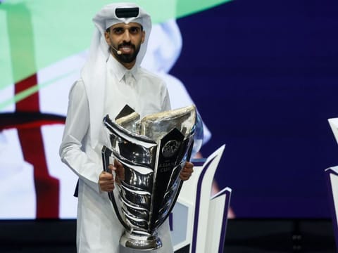 Qatari footballer Hassan Al Haydos carries the Asian Cup trophy during the draw for the AFC Asian Cup in Doha on Thursday.