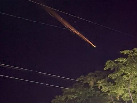 This video grab taken from video footage recorded on May 10, 2023 and released to AFP courtesy of Twitter user 'shokosan' shows fiery streaks of light across the night sky at an unconfirmed location in the Japanese islands of Okinawa.