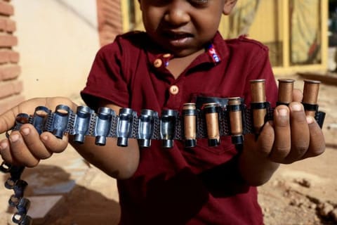 A boy holds bullet cartridges as clashes between Sudan's paramilitary Rapid Support Forces (RSF) and the army continue, in Khartoum North, Sudan, May 13, 2023.