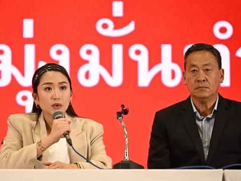 Pheu Thai Party's prime ministerial candidates Paetongtarn Shinawatra (left) and Srettha Thavisin address the media at the party's headquarters in Bangkok on May 15, 2023. Thailand's opposition Pheu Thai party said it was willing to join a coalition government led by the reformist Move Forward Party, after voters kicked out the ruling army-linked government.