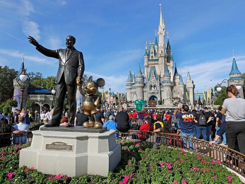 A statue of Walt Disney and Micky Mouse stands in front of the Cinderella Castle at the Magic Kingdom at Walt Disney World in Lake Buena Vista, Florida.