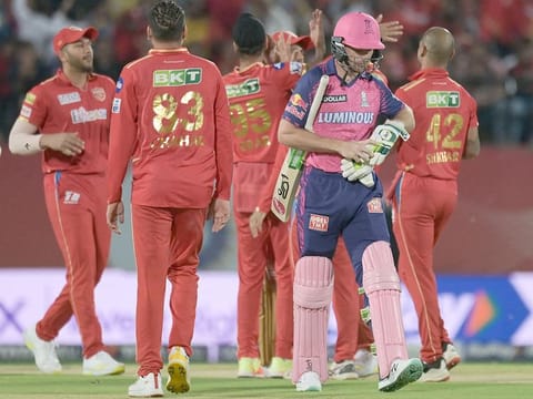 Rajasthan Royals' Jos Buttler (front, R) walks back to the pavilion after his dismissal during the IPL match against Punjab Kings at the Himachal Pradesh Cricket Association Stadium in Dharamsala on May 19, 2023.