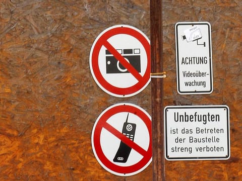 Signs forbidding photography and mobile phones are pictured on a fence to part of the construction site of the new headquarters of Germany's intelligence agency Bundesnachrichtendienst (BND) in Berlin, July 11, 2011.
