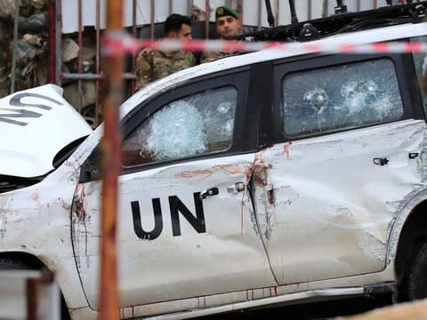 Lebanese soldiers stand behind a damaged vehicle after a UN peacekeepers convoy came under fire in the Al Aqbiya village, south Lebanon, on Dec. 15, 2022.