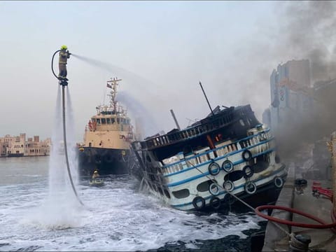 Firefighters put out the flames that engulfed in a wooden boat (dhow) in Dubai early on Monday.,