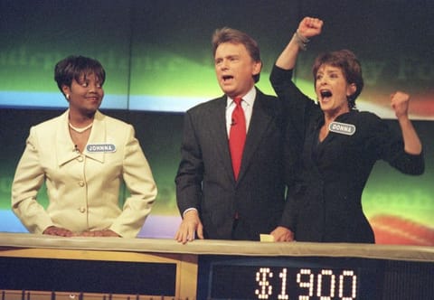 Johnna Goodwin watches as Donna Handel, right, reacts after winning on 'Wheel of Fortune', with host Pat Sajak during a taping of the game show in 1999.
