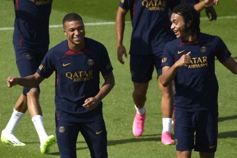 Paris Saint-Germain's forward Kylian Mbappe (left) and his younger brother Ethan Mbappe share a laugh during a training session PSG football club at Poissy in Paris.