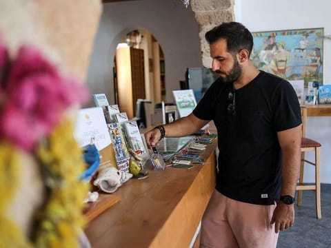 Hotel owner Lefteris Laoudikos checks the room keys at the lobby of the family's hotel "Ekaterini", at the village of Kiotari, on the island of Rhodes, Greece.