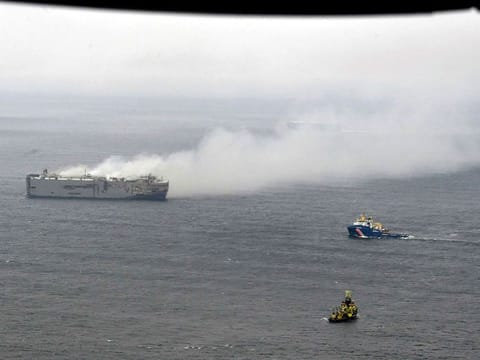 Smoke is seen from a freight ship in the North Sea, about 27 kilometers (17 miles) north of the Dutch island of Ameland, Thursday, July 27, 2023. A cargo ship packed with nearly 3,000 cars was still ablaze Thursday close to a world-renowned bird habitat off the Dutch coast as firefighters and salvage crews waited for the flames to subside before attempting to board the vessel.