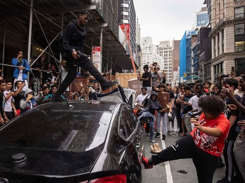 People jump on a car during riots sparked by Twitch streamer Kai Cenat, who announced a "givaway" event, in New York's Union Square.