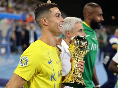 Al Nassr's Cristiano Ronaldo celebrates with the trophy after winning the Arab Club Champions Cup final.