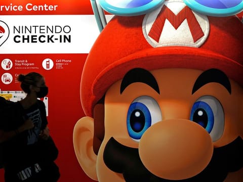 File photo: A person passes an ad featuring the Nintendo character Mario at Narita airport in Narita near Tokyo. Charles Martinet, the voice of Mario in Nintendo games since the 1990s, is stepping down, Nintendo of America confirmed.