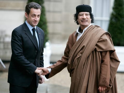 French President Nicolas Sarkozy, left, greets Libyan leader Col. Muammar Gadhafi upon his arrival at the Elysee Palace, in Paris Dec. 10, 2007.