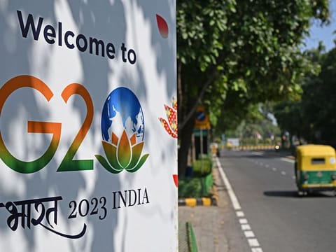 An auto-rickshaw drives past a billboard installed along a street ahead of the two-day G20 summit in New Delhi on September 5, 2023.