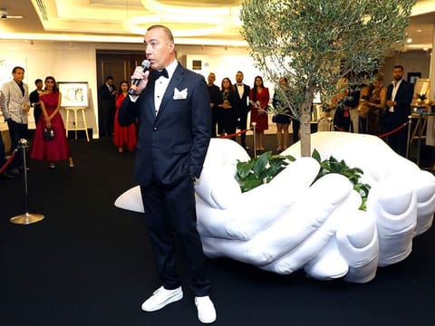 Sculptor Lorenzo Quinn, son of Hollywood actor Anthony Quinn, at the Art be a Part auction Dubai. His artwork 'Give' in the backdrop fetched Dh360,000 at the auction.