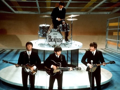 The Beatles, foreground from left, Paul McCartney, George Harrison, John Lennon and Ringo Starr on drums perform on the CBS "Ed Sullivan Show" in New York on Feb. 9, 1964.