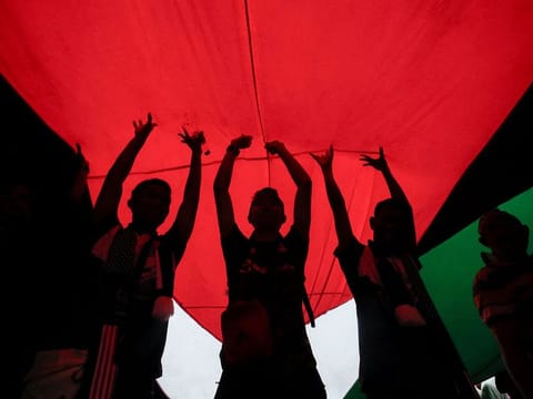 Protesters hold a giant Palestinian flag during a protest in support of Palestinians in Gaza