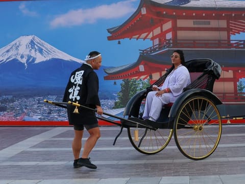 A visitor enjoys a traditional Japanese rickshaw ride on a Jinriksha at the Japan Culture Con at Burj Park, Dubai