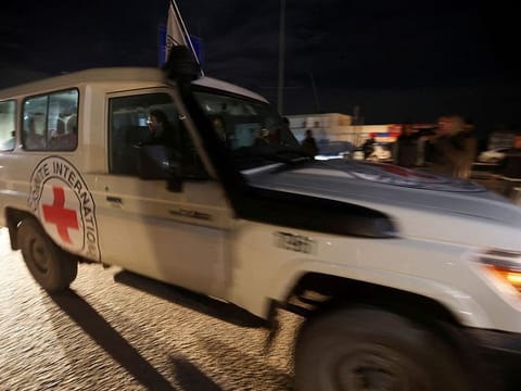 A Red Cross vehicle carrying hostages abducted by Hamas militants during the October 7 attack on Israel, arrives at Rafah border, amid a hostages-prisoners swap deal between Hamas and Israel, in the southern Gaza Strip.