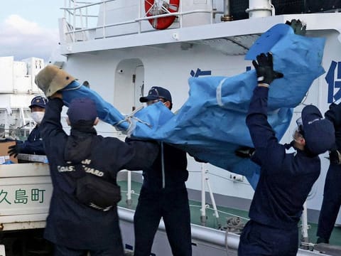 The members of Japanese Coast Guard carry the debris which are believed to be from the crashed U.S. military Osprey aircraft, at a port in Yakushima, Kagoshima prefecture, southern Japan, Monday, Dec. 4, 2023.