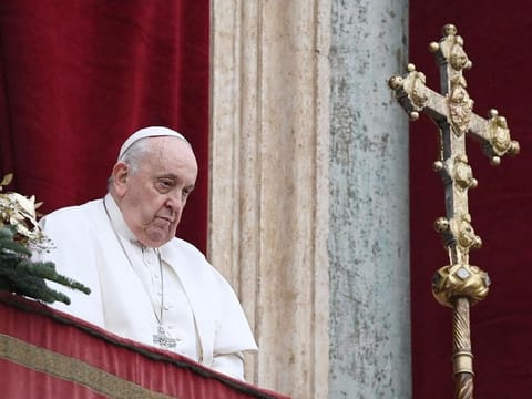 Pope Francis stands at the balcony of St. Peter's basilica to delivers the Christmas Urbi et Orbi blessing in St. Peter's Square at The Vatican on December 25, 2023.