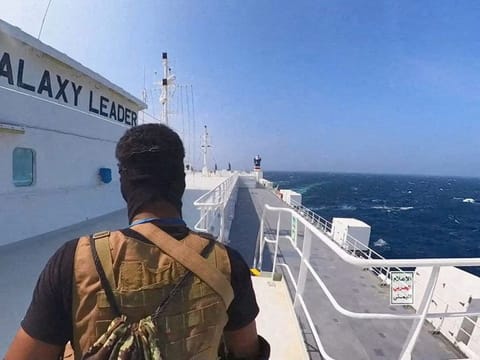 An Al Houthi militant stands on the Galaxy Leader cargo ship in the Red Sea in this photo released November 20, 2023.