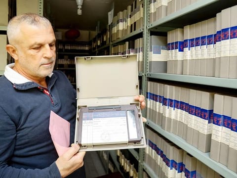 An employee shows a tape at the archives department of the Lebanon TV station 'Tele Liban' in Beirut.