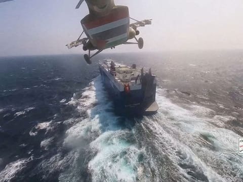 A Houthi helicopter flies over the Galaxy Leader cargo ship in the Red Sea. The vessel, linked to Israeli interests, was seized by the Houthis in November 2023
