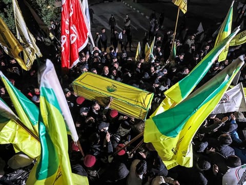 Members of Iraq's Popular Mobilisation Forces (PMF) paramilitaries carry the bodies of two of their slain comrades during their funeral at the PMF headquarters in Baghdad on January 4, 2024.