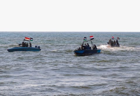 Members of the Yemeni Coast Guard affiliated with Al Houthi group patrol the sea as demonstrators march through the Red Sea port city of Hodeida.