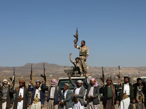 Al Houthi militants and their tribal supporters hold up their firearms during a protest against recent US-led strikes on Al Houthi targets, near Sana'a, Yemen, on January 14, 2024.
