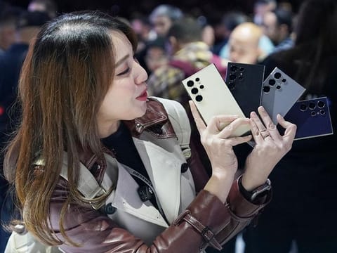 An influencer poses with Samsung’s new Galaxy S24 Ultra model phones offering AI functions at the Galaxy Unpacked event in San Jose, California, on January 17, 2024.