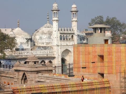 A worker stands on a temple rooftop adjacent to the Gyanvapi Mosque in the northern city of Varanasi.