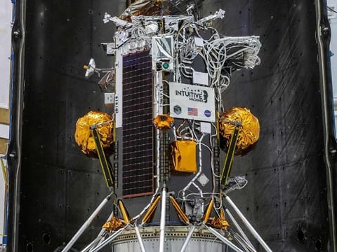 The photo shows the Nova-C lunar lander encapsulated within the fairing of a SpaceX Falcon 9 rocket in preparation for launch, as part of NASA’s CLPS (Commercial Lunar Payload Services) initiative and Artemis campaign in Kennedy Space Center, Florida.