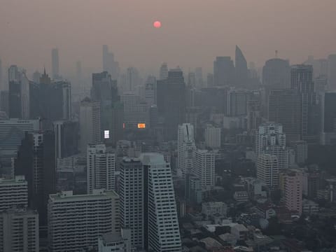 A view of the city amid air pollution during sunrise in Bangkok, Thailand.