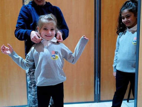 Schoolchildren try on the new school uniforms, which will be used in some elementary schools of the Beziers city at the Palais des Congres in Beziers, southern France.
