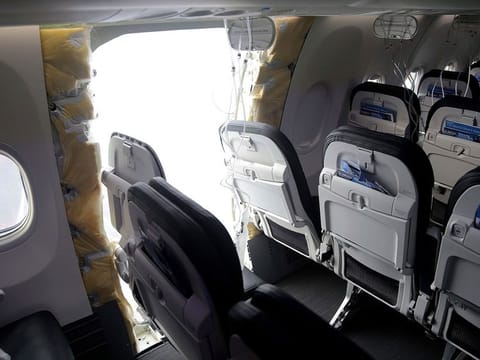 This photo released by the National Transportation Safety Board shows a gaping hole where the paneled-over door had been at the fuselage plug area of Alaska Airlines Flight 1282, Jan. 7, 2024