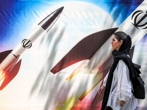A banner depicting launching missiles bearing the emblem of the Islamic Republic of Iran in central Tehran on April 15, 2024.