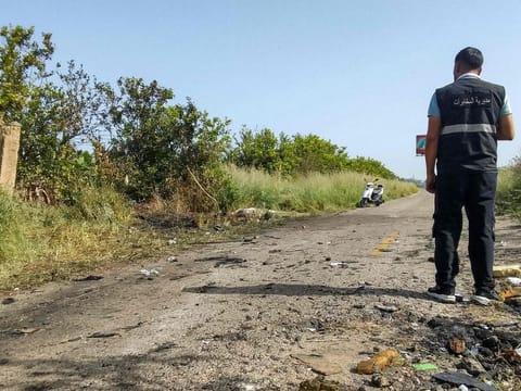 A member of the Lebanese intelligence service stands at the site of an Israeli strike on a vehicle in the Adloun plain area, between Lebanon's southern cities of Sidon and Tyre, on April 23, 2024.